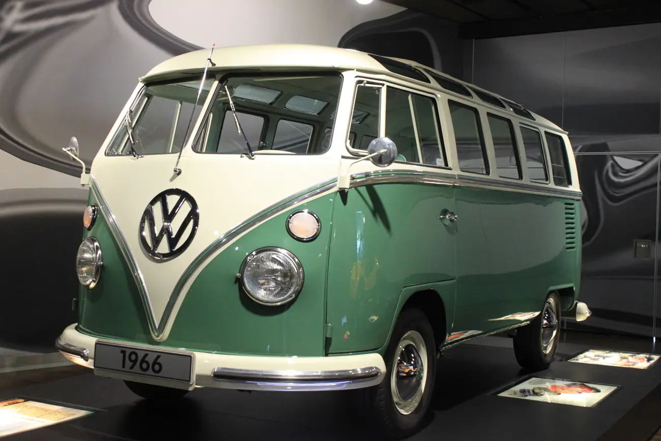 A green and white 1966 Volkswagen T1 Transporter in a museum exhibit